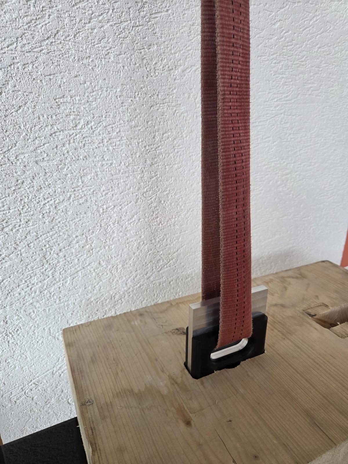 Sangle de levage passée dans l’ancrage, inséré dans une pièce de bois